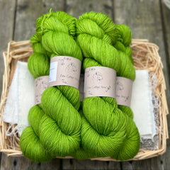 Five skeins of hand dyed yarn in a semi-solid zingy saturated green. 