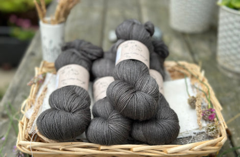 four skeins of semi-solid dark grey yarn