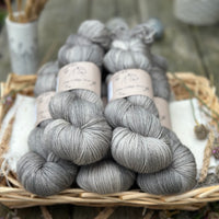 Five skeins of semi-solid medium toned grey yarn