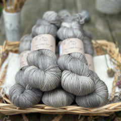 Five skeins of semi-solid medium toned grey yarn