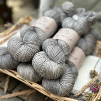 Five skeins of semi-solid medium toned grey yarn