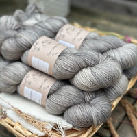 Five skeins of semi-solid medium toned grey yarn