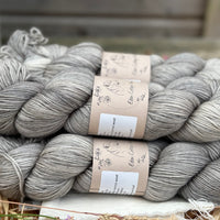 Five skeins of semi-solid medium toned grey yarn