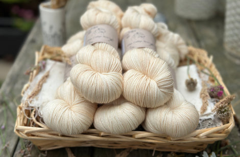 Five skeins of hand dyed yarn in a semi-solid very light cream.