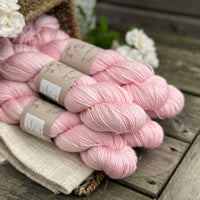 five skeins of hand dyed yarn in a soft pink colour