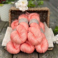 five skeins of hand dyed yarn in an apricot coral colour