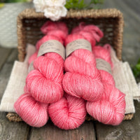 five skeins of hand dyed yarn in a pinkish coral colour