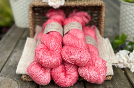 five skeins of hand dyed yarn in a pinkish coral colour