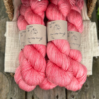 five skeins of hand dyed yarn in a pinkish coral colour