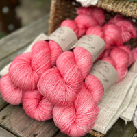 five skeins of hand dyed yarn in a pinkish coral colour