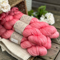 five skeins of hand dyed yarn in a pinkish coral colour