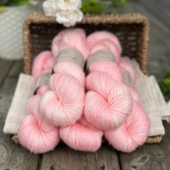 five skeins of hand dyed yarn in a soft pinkish coral colour