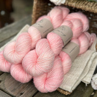 five skeins of hand dyed yarn in a soft pinkish coral colour