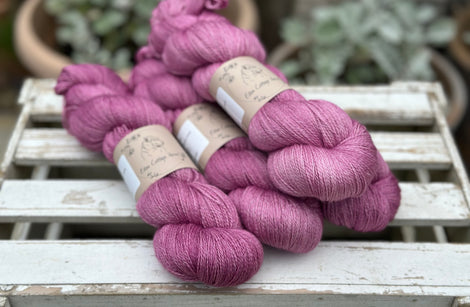 Four skeins of light purpley-pink yarn