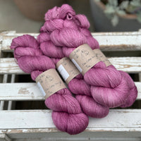 Four skeins of light purpley-pink yarn