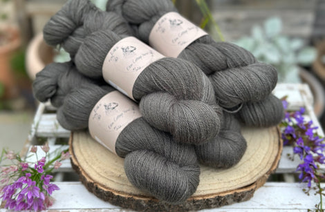 Five skeins of dark grey laceweight yarn