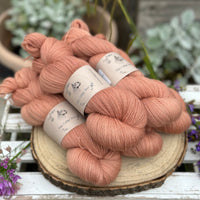 Five skeins of orangey pink yarn