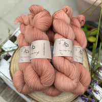 Five skeins of orangey pink yarn