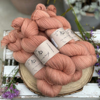 Five skeins of orangey pink yarn