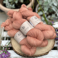 Five skeins of orangey pink yarn