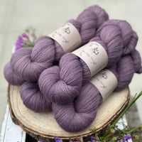 Five skeins of purple laceweight yarn