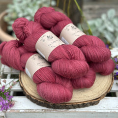 Five skeins of purpley red laceweight yarn