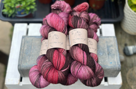 Five skeins of variegated pink, purple and red yarn