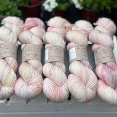 Five skeins of variegated cream, pink, yellow and purple yarn