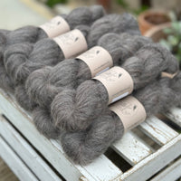 9 skeins of fluffy dark grey yarn