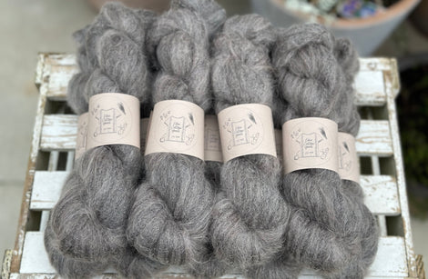 9 skeins of fluffy dark grey yarn