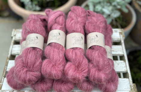 9 skeins of fluffy purpley-red yarn