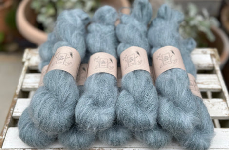 9 skeins of fluffy blue-green yarn