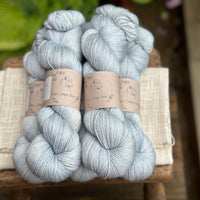 five skeins of hand dyed yarn in a semi-solid pale blue colour