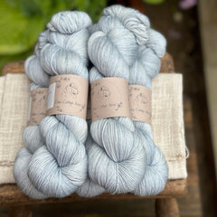 five skeins of hand dyed yarn in a semi-solid pale blue colour