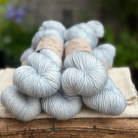 five skeins of hand dyed yarn in a pale soft blue, viewed end-on.