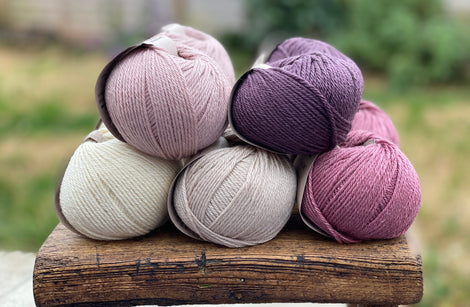 10 balls of yarn in five colours, a fade of pink/purple