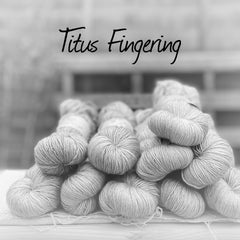 Black and white image of skeins of yarn with "Titus Fingering" overlaid in black text